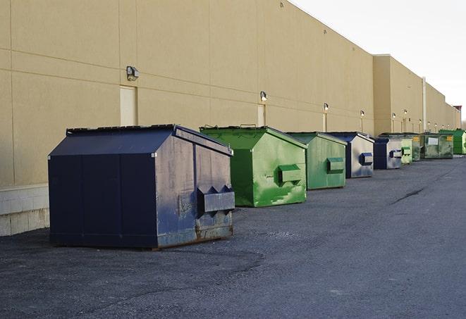 construction workers loading debris into dumpsters on a worksite in Elverta, CA